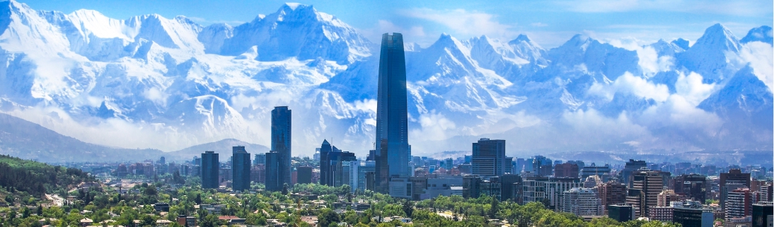 Santiago Panorama de Santiago do Chile com arranha-céus ao centro e a Cordilheira dos Andes nevada ao fundo.