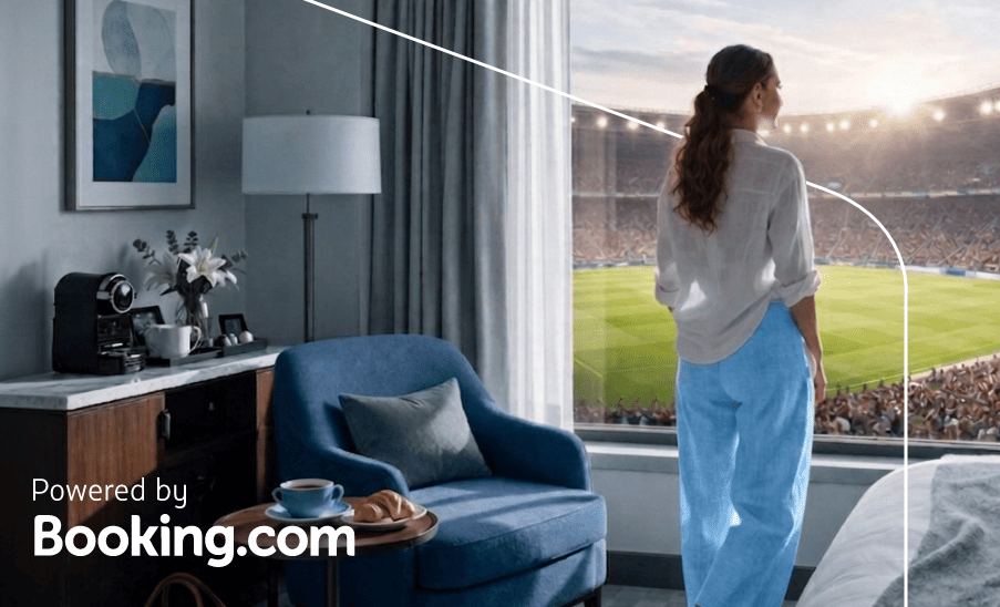 Kansas City Mujer mira por la ventana de una habitación de hotel con vista directa a un estadio