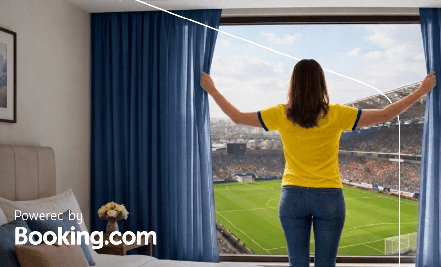 Mujer abre cortinas de una habitación de hotel con vista directa a un estadio; texto “Powered by Booking.com”.