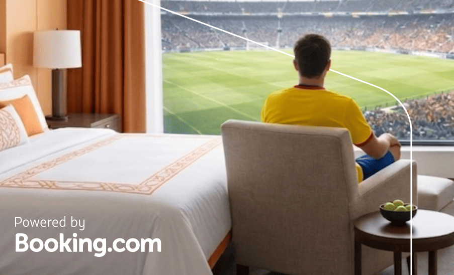Hombre sentado junto a la ventana de una habitación de hotel con vista a la cancha; texto “Powered by Booking.com”.