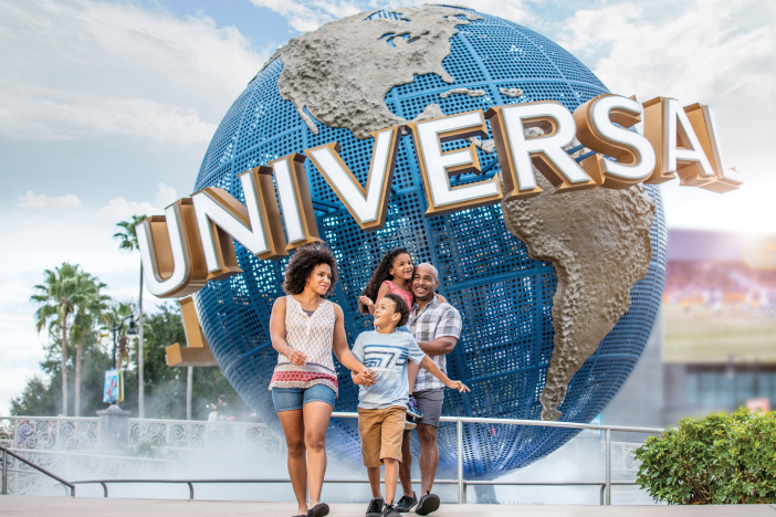 Familia caminando y sonriendo frente a Universal Orlando Resort